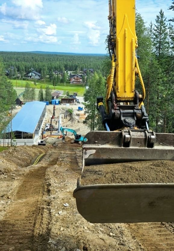 Kaivinkone pohjatöissä rinteen juurella
